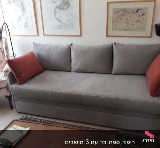 ספה אפורה עם כריות כתומות על משענות